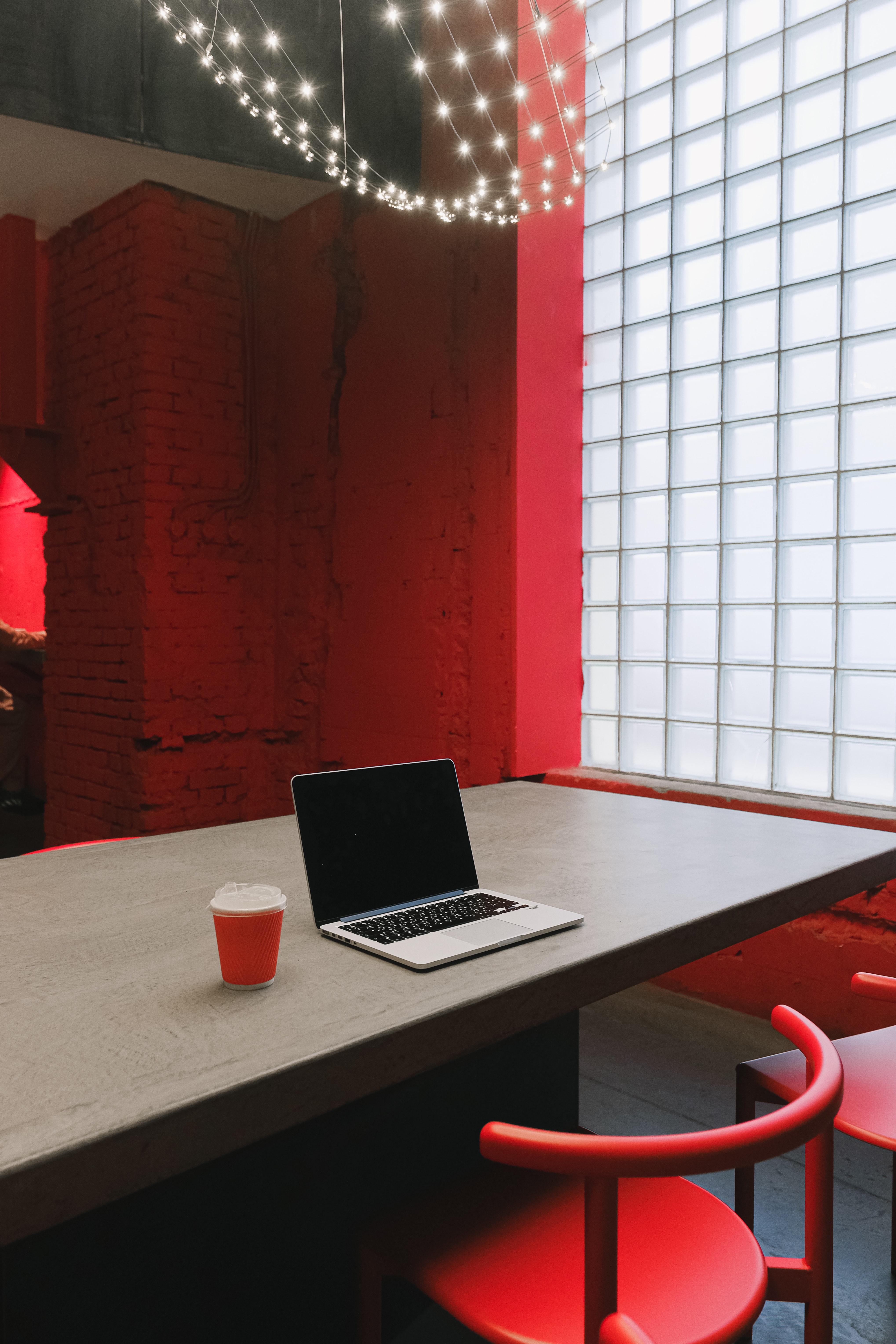 Podnik s červenými stenami, stoličkami a efektívnou presklenou stenou