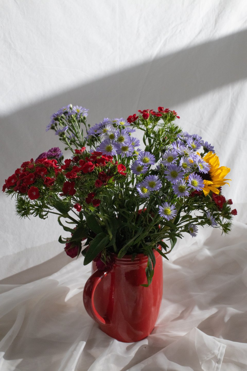 Červená váza s farebnými kvetmi