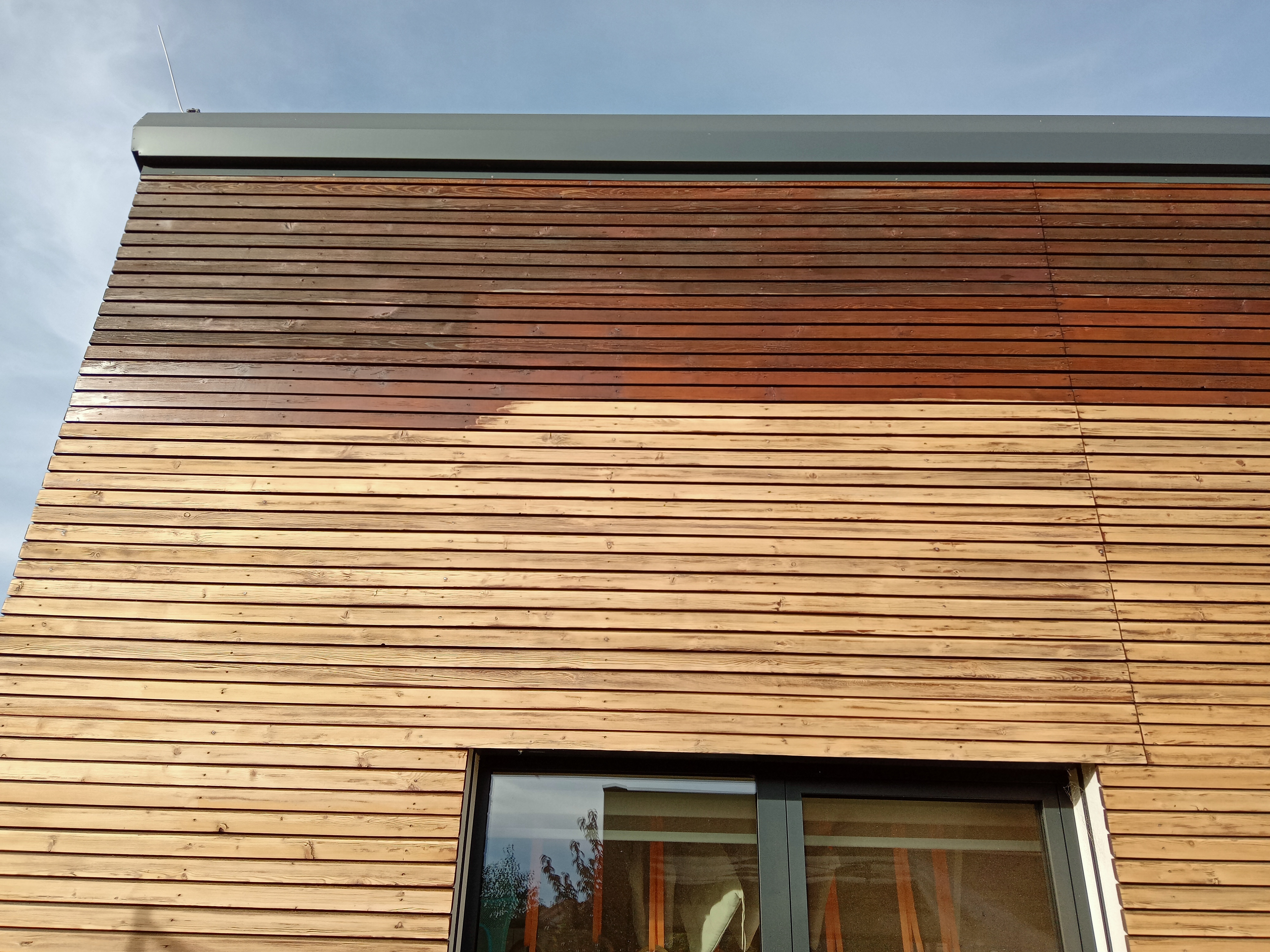 Drevený obklad na dome počas natierania lazúry na drevo Flugger Wood Tex 03